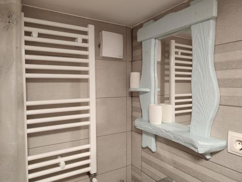 a bathroom with a mirror and a shelf with towels at Camera de familie in Vatra Dornei
