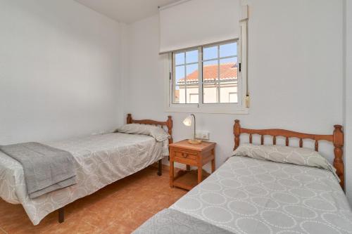 a bedroom with two beds and a window at Casa del mar Salobreña in Salobreña