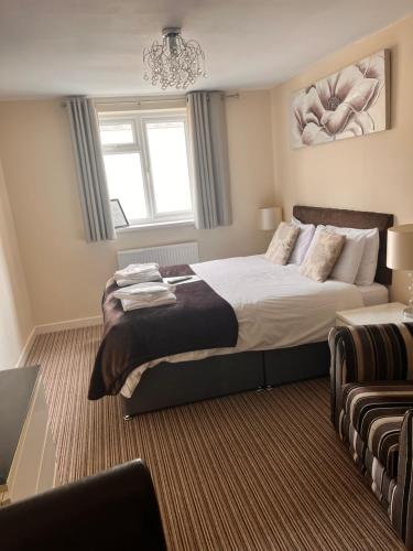 a bedroom with a large bed and a chandelier at The Oxfordshire in Blackpool