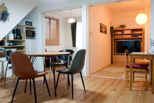 a living room with a table and chairs and a kitchen at EK House Kamata A, Simple&Stylish, Near Haneda/Shinagawa, one floor in Tokyo