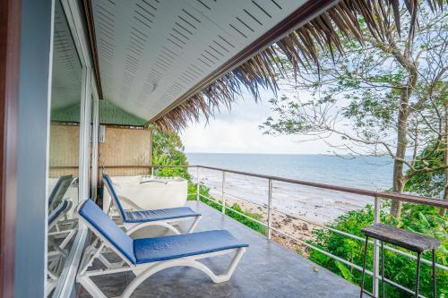 a porch with two chairs and a view of the ocean at Koh Jum Resort in Ko Jum