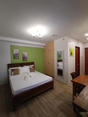 een slaapkamer met een groot bed en een tafel bij Mesavirre Garden Residences in Bantud Hacienda