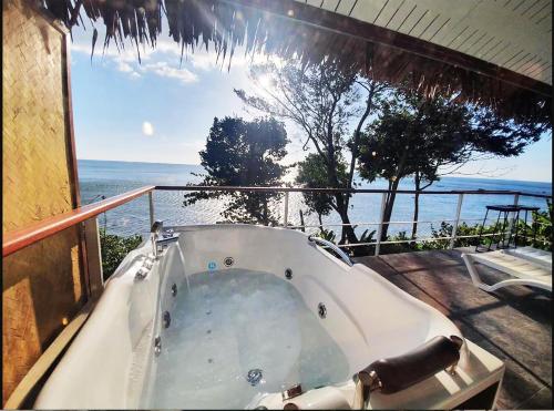 a bath tub on a balcony with a view of the ocean at Koh Jum Resort in Ko Jum