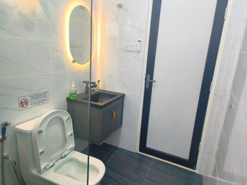 a bathroom with a toilet and a sink and a mirror at Taiping Vacation Home in Taiping