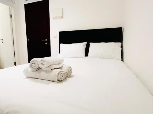 a bedroom with a white bed with towels on it at Underground in Tel Aviv