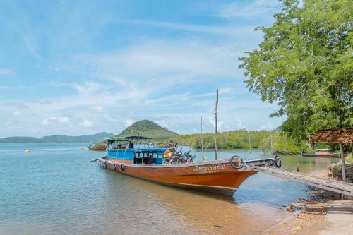 a boat parked at a dock on the water at Koh Jum Resort in Ko Jum