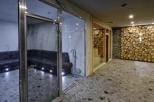 Habitación con sofá y puerta de cristal en Luxory aparthotel in 4 star SPA hotel st Ivan Rilski, Bansko, en Bansko