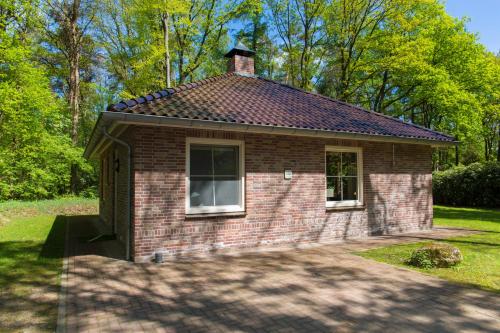 a small brick building with a window in a yard at Bungalowpark Bij de Bronnen in Nutter