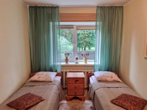 two beds in a room with a window at Tiigi Villa in Haapsalu