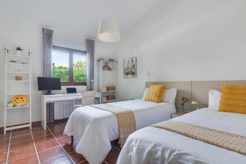 1 dormitorio con 2 camas y escritorio con ordenador en Home2Book Villa El Naranjo, Garden & Pool, en Valsequillo
