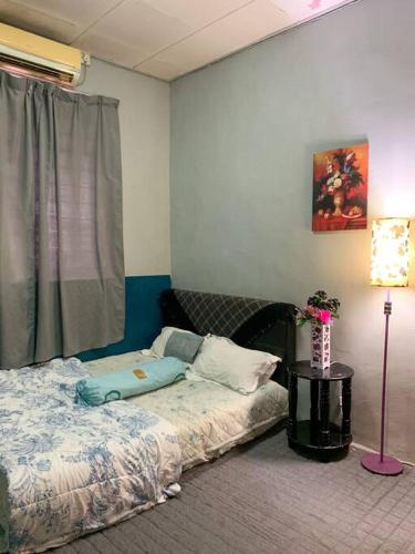 um quarto com uma cama, uma janela e um candeeiro em GayaMas Homestay em Sandakan