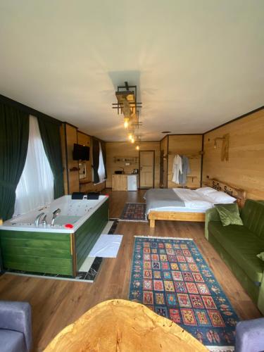 Cette chambre comprend une baignoire, un lit et un canapé. dans l'établissement SoOnSuitApart, à Çamlıhemşin