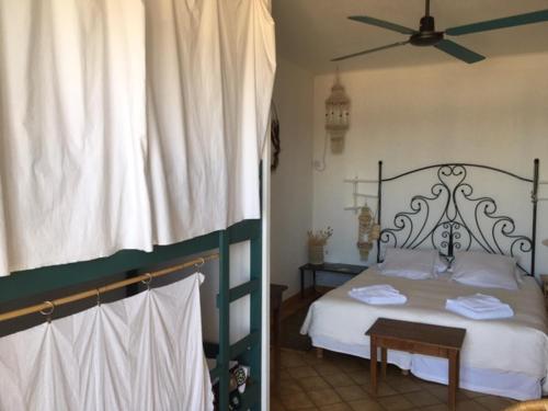 una camera con letto e ventilatore a soffitto di Hôtel Lido Beach a Hyères