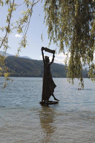 a statue of a woman standing in a body of water at Familienhotel Steindl in Millstatt