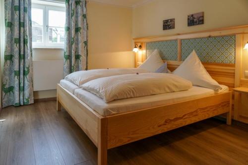 a bedroom with a large bed with a wooden frame at Fürstnerhof Chiemsee in Rimsting
