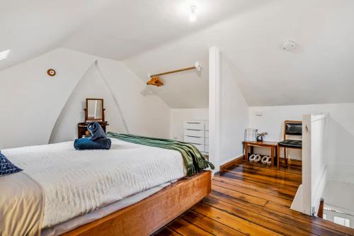 Adorable 1855 cottage - South Hobart Village في هوبارت: غرفة نوم عليها سرير محشوة