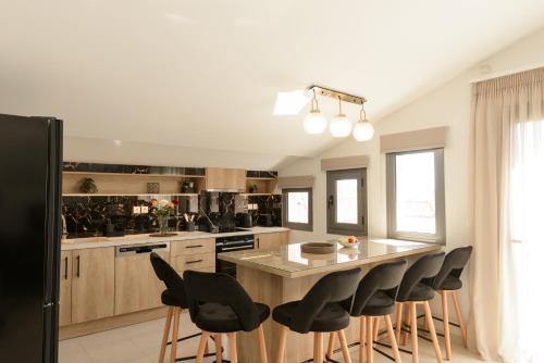 a kitchen with a large island with chairs around it at Zissis Suites Downtown Apartment in Zakynthos Town