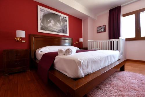 a bedroom with a large bed with red walls at Le Cinéma in Formia