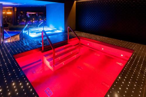 a hot tub in a room with red lighting at Break Sokos Hotel Bomba in Nurmes