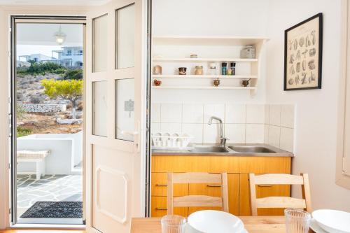 a kitchen and dining room with a view of the ocean at Gaia Seaview Residence Irakleia in Áyios Yeóryios