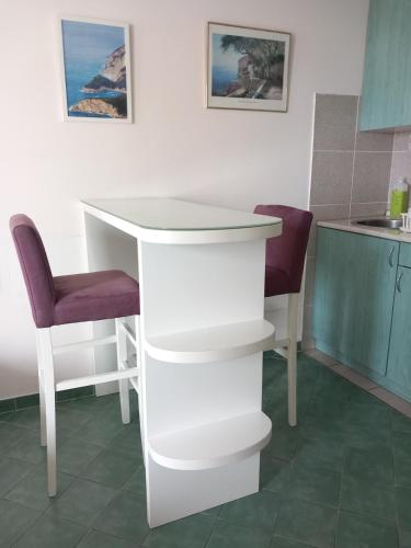 a white table and two chairs in a kitchen at Apartment Budva in Budva