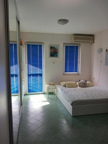 a bedroom with a bed with a tiled floor and windows at Apartment Budva in Budva