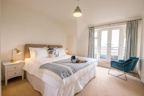 een slaapkamer met een bed, een stoel en een raam bij Spindrift, Felixstowe in Felixstowe