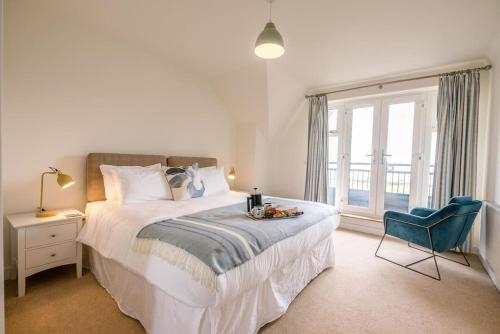a bedroom with a bed and a chair and a window at Spindrift in Felixstowe