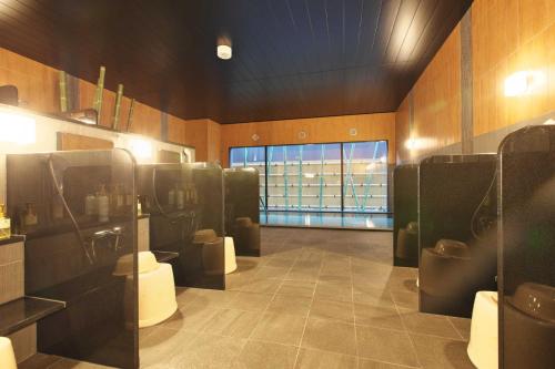 a bathroom with sinks and toilets in a room at Hotel Route Inn Grand Nakano Obuse in Nakano