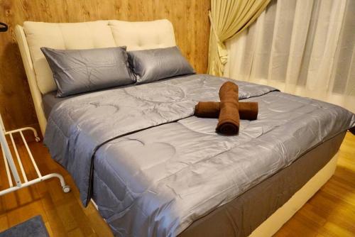 uma cama com um urso de peluche castanho em Teega 12pax Cozy 4BR w Bathtub by Our Stay em Nusajaya