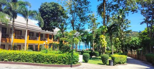 un edificio con árboles y arbustos delante de él en Diamond Cave Resort en Railay Beach