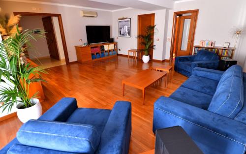 a living room with blue couches and a wooden floor at Le Cinéma in Formia