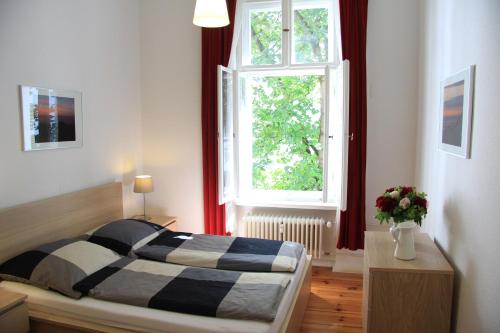 a bedroom with a bed in front of a window at Nollendorf Apartments in Berlin