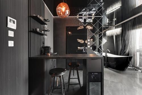a kitchen with a counter and stools in a room at Hollywood Jacuzzi Suite by Downtown Apartments in Gdańsk