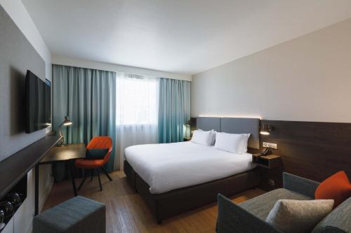 Habitación de hotel con cama, escritorio y sillas en Holiday Inn Toulon City Centre, an IHG Hotel en Toulon