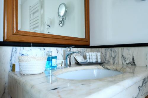 a bathroom counter with a sink and a mirror at Le Cinéma in Formia