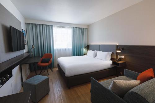 une chambre d'hôtel avec un lit et un canapé dans l'établissement Holiday Inn Toulon City Centre by IHG, à Toulon