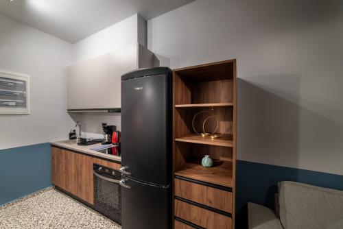 a kitchen with a black refrigerator in a room at MOD 15 City Centre in Agios Nikolaos