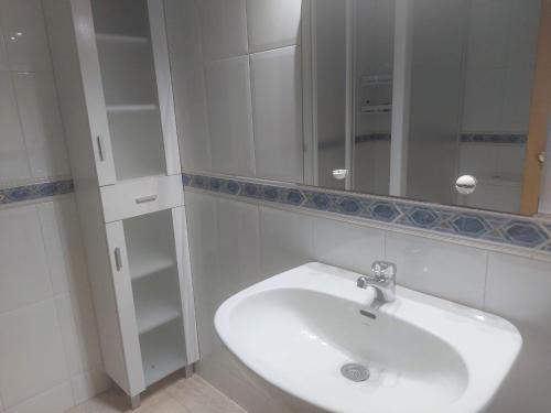 La salle de bains est pourvue d'un lavabo blanc et d'un miroir. dans l'établissement Rentalmar Internacional, à Cambrils