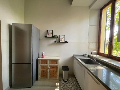 uma cozinha com um frigorífico de aço inoxidável e um lavatório em Casa del Riccio, Palio Siena em Siena