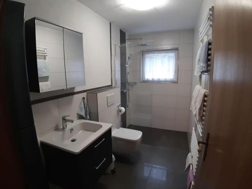 a white bathroom with a sink and a toilet at Ferienapartment Karle in Nordrach