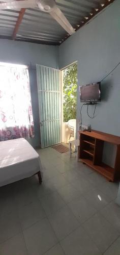 een slaapkamer met een bed en een tv aan de muur bij Casa de Doña Horte in Catemaco