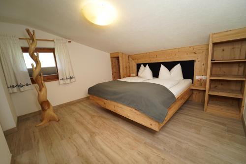 a bedroom with a large bed and a book shelf at Ferienwohnungen Hinterholzer in Sankt Jakob in Haus