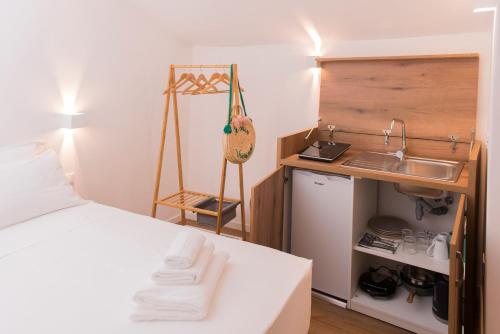 a room with a bed and a sink and a kitchen at ALMAMI Loft & Rooms in Monopoli