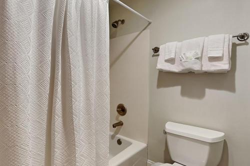 a bathroom with a toilet and a shower with towels at Florencia #207 in Perdido Key