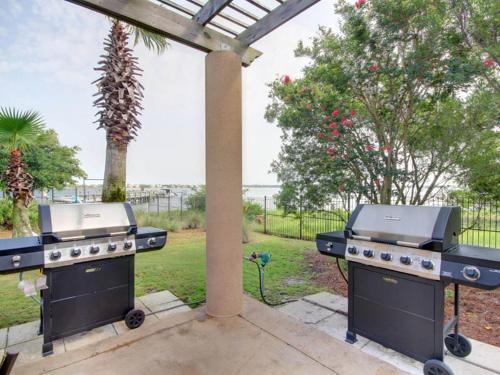 two bbqurgers sitting under a pergola on a patio at Florencia #207 in Perdido Key