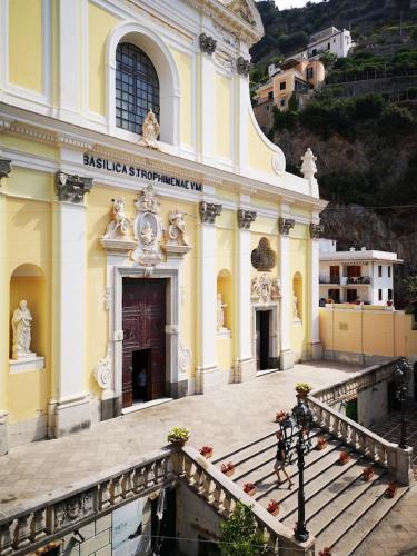 a large yellow building with a staircase in front of it at allafontanina in Minori