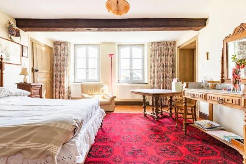 a bedroom with a bed and a desk and a table at Ferme De Guersignies B&B in Bas-Lieu