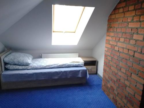 a bedroom with a bed and a brick wall at Arkadia 