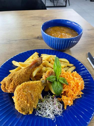 un plato azul de comida con pollo frito y papas fritas en Arkadia, 
